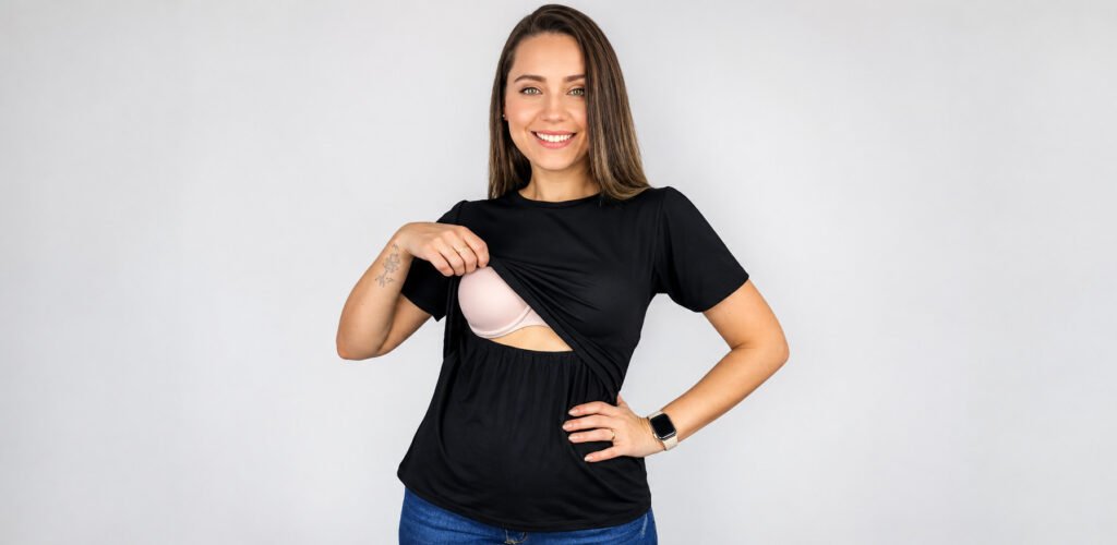 Mulher vestindo blusa preta de amamentação com abertura frontal que facilita o acesso ao seio.