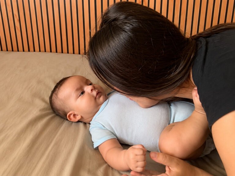Mãe olhando carinhosamente para o bebê durante o pós-parto